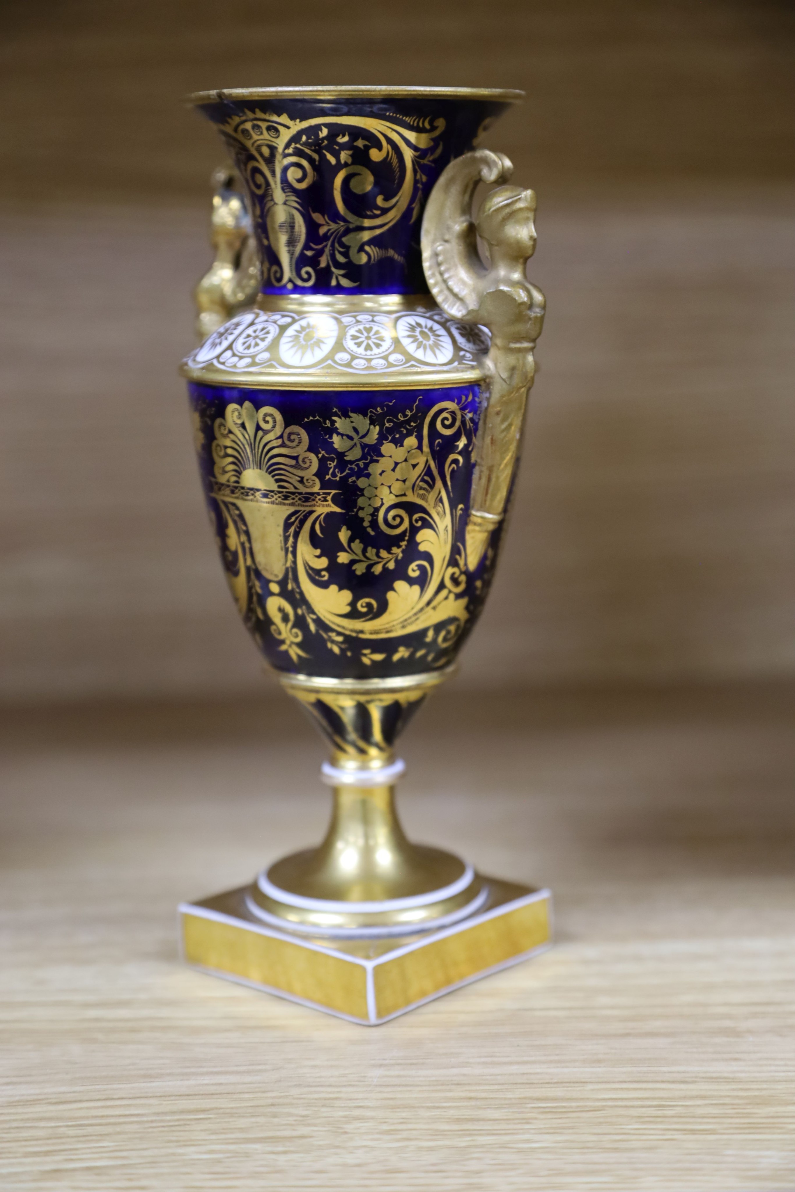A garniture of three early 19th century English porcelain vases, c.1815-20, each painted with topographical views, tallest 26cm